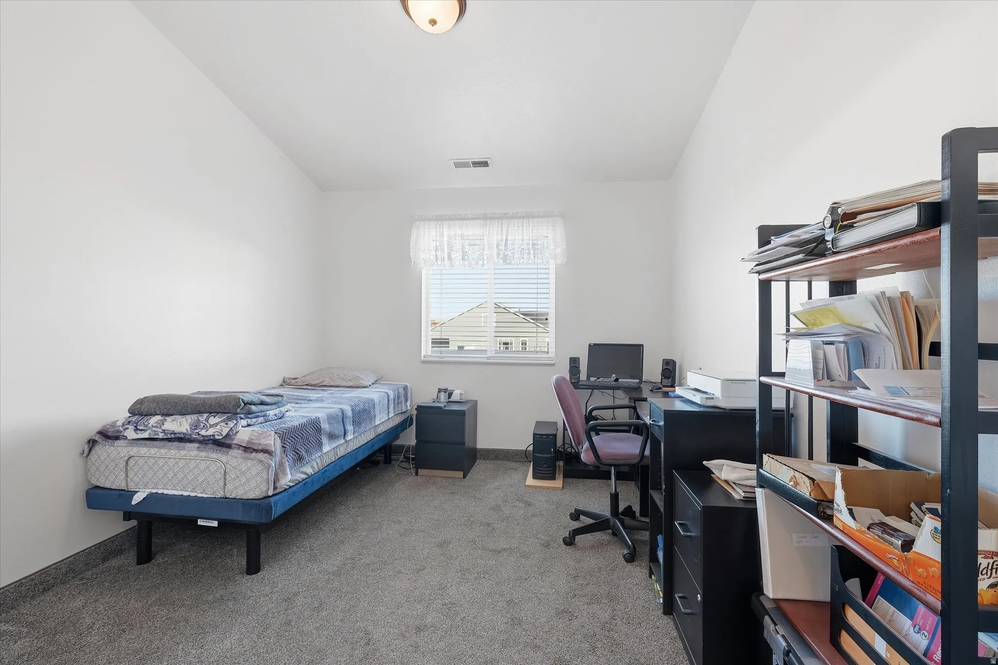 Carpeted room with a single window and a ceiling-mounted light fixture