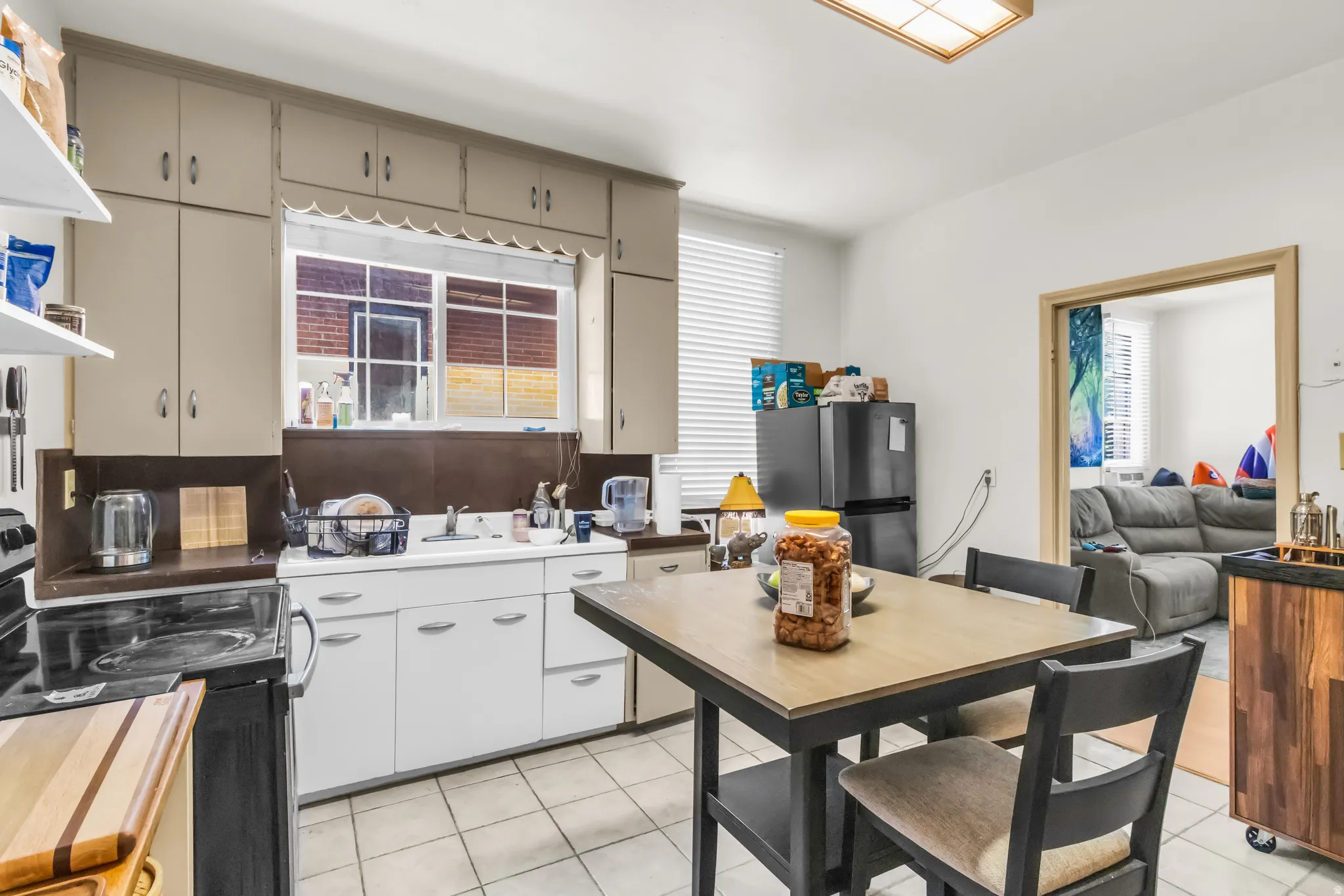 Kitchen featuring white cabinetry, tile flooring, and a built-in window