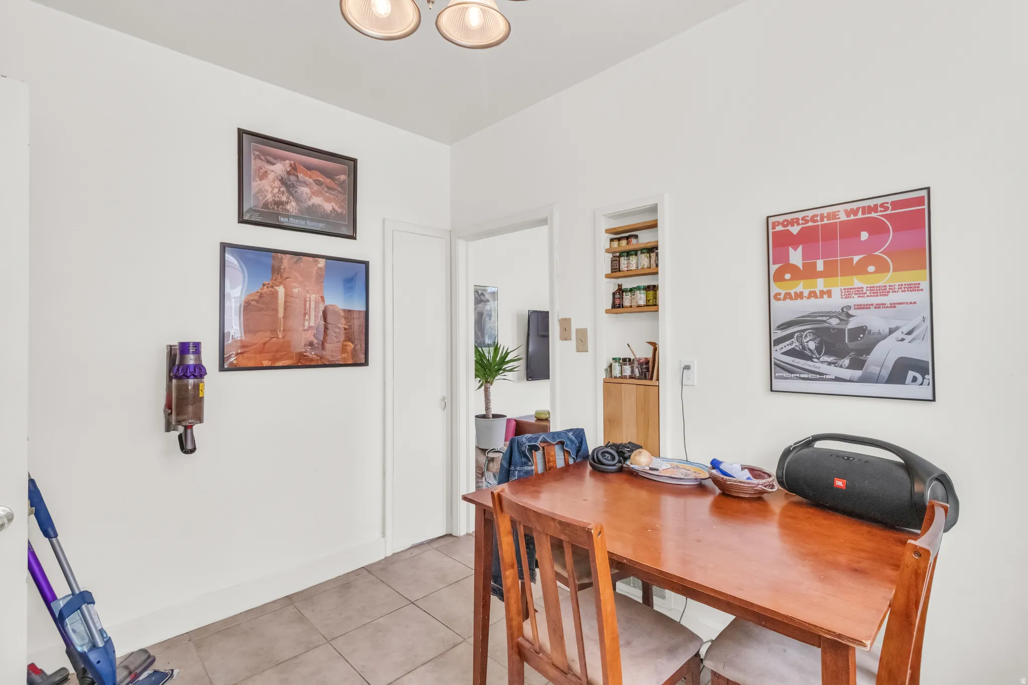 Recessed shelving with wood-finish cabinetry, tile flooring, and overhead lighting