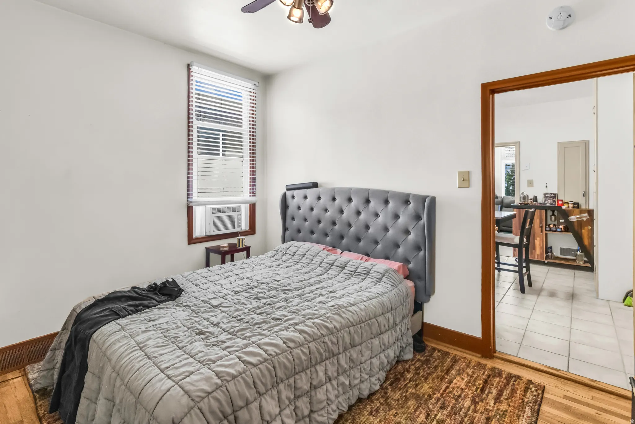 Hardwood flooring, white wall paint, wood window trim, wood door trim, ceiling fan