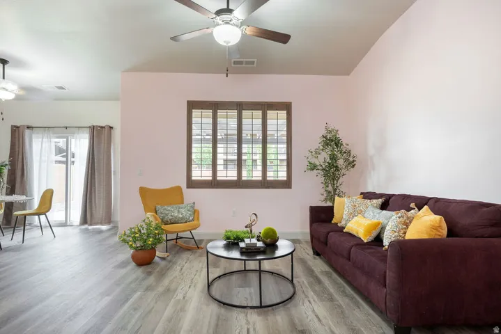 Vaulted ceiling with a ceiling fan, wood-finish flooring, and a sliding glass door