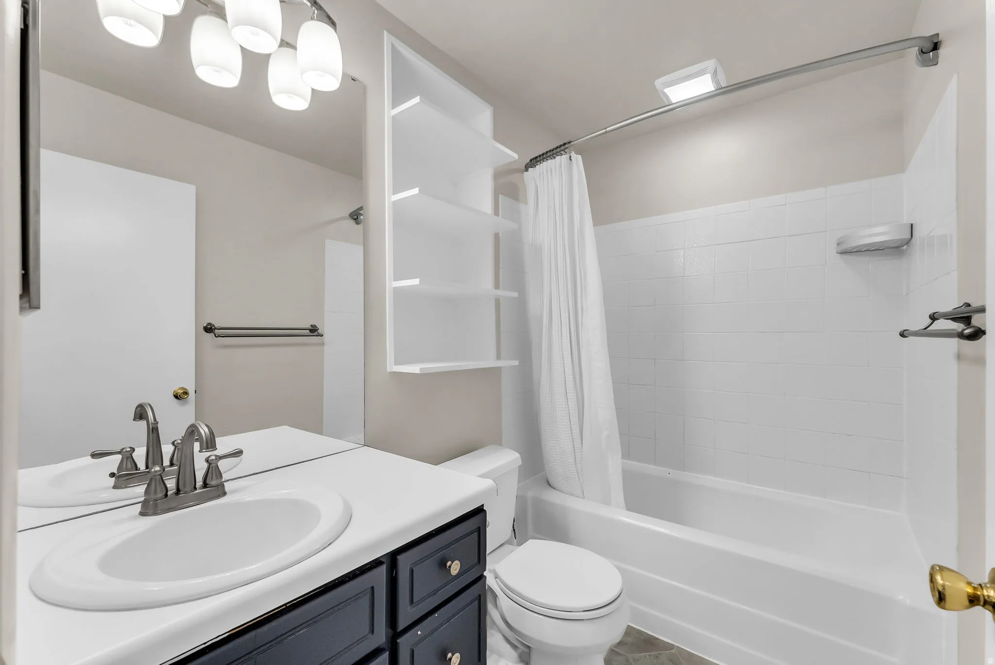 Bathroom featuring a vanity with a white countertop, sink, and dark cabinetry
