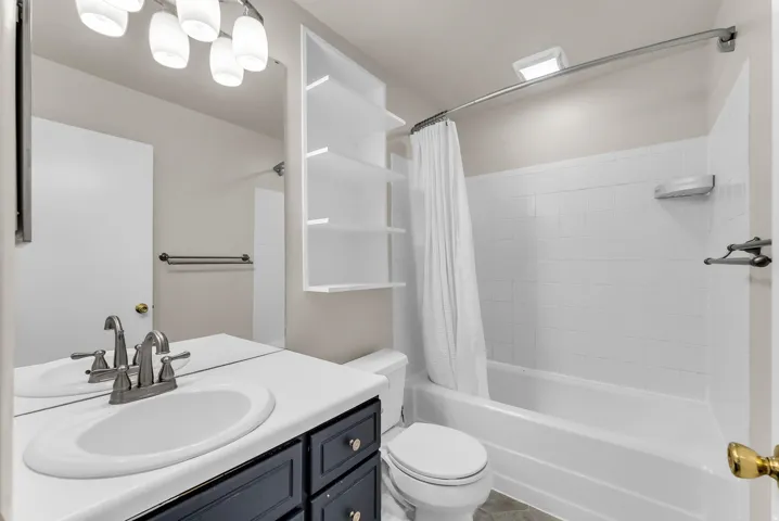 Bathroom featuring a vanity with a white countertop, sink, and dark cabinetry