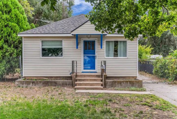 Front exterior with horizontal siding, a vibrant blue entry door, and a covered porch entry