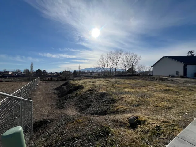 Expansive undeveloped lot with partial chain-link fencing