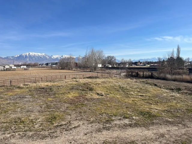 Expansive lot with partial fencing and mountain scenery
