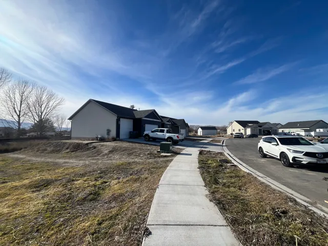 Modern home situated on a spacious lot with a concrete walkway leading to the entry