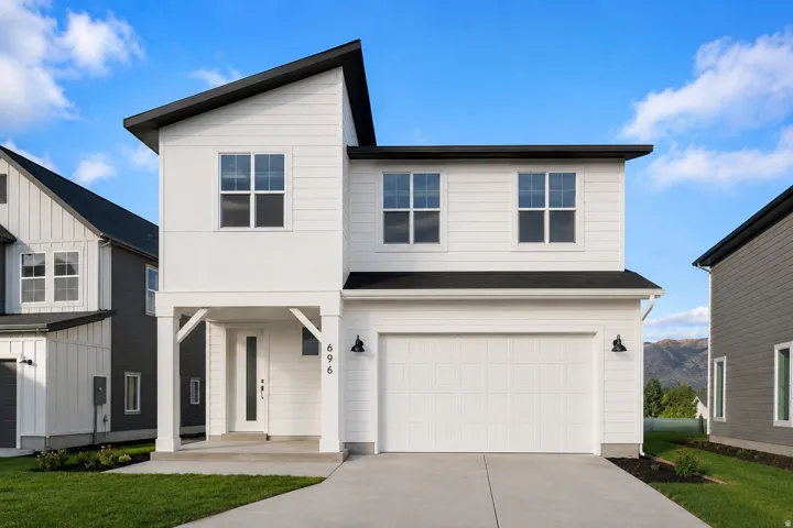 Contemporary two-story exterior with white siding, black-trimmed windows, and an attached two-car garage