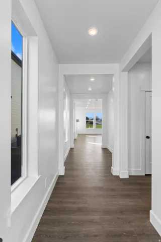 Hallway featuring recessed lighting, wood-finish flooring, and white trim