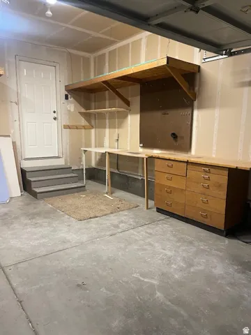Concrete flooring, built-in shelving, integrated workbench, and dedicated storage cabinetry