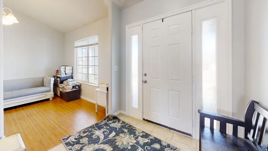 Entryway featuring a paneled door with side lights, tile flooring, and overhead lighting