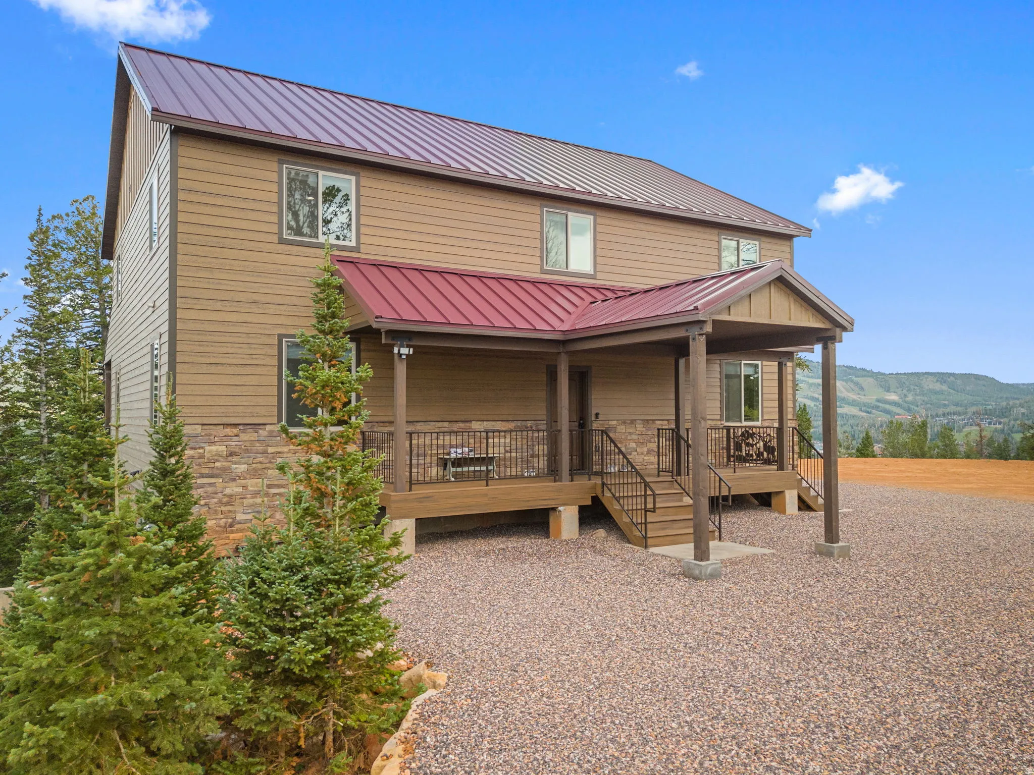 Two-story residence featuring siding and stone veneer exterior