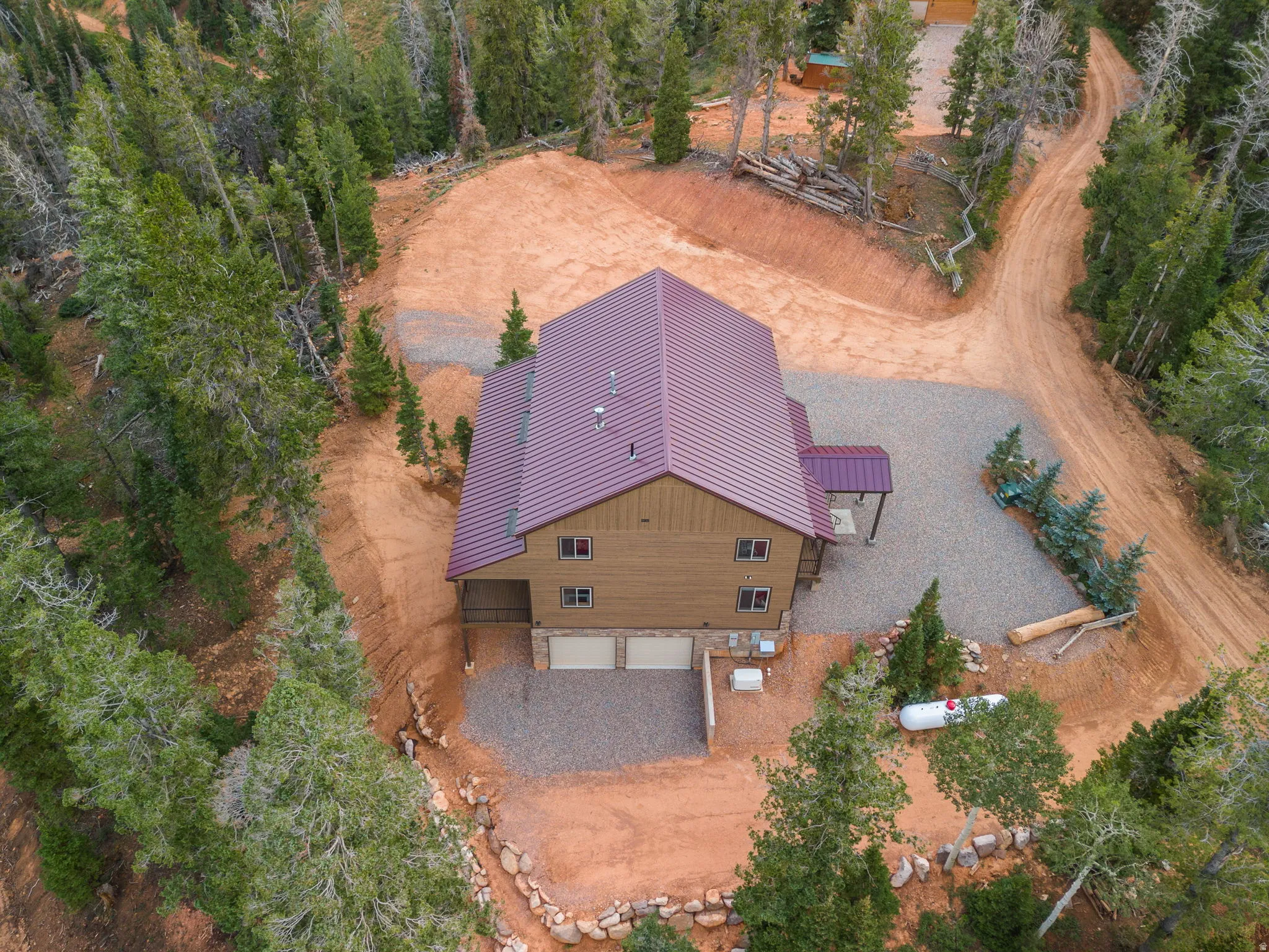 Two-story residence with a metal roof, attached two-car garage, and a covered entry