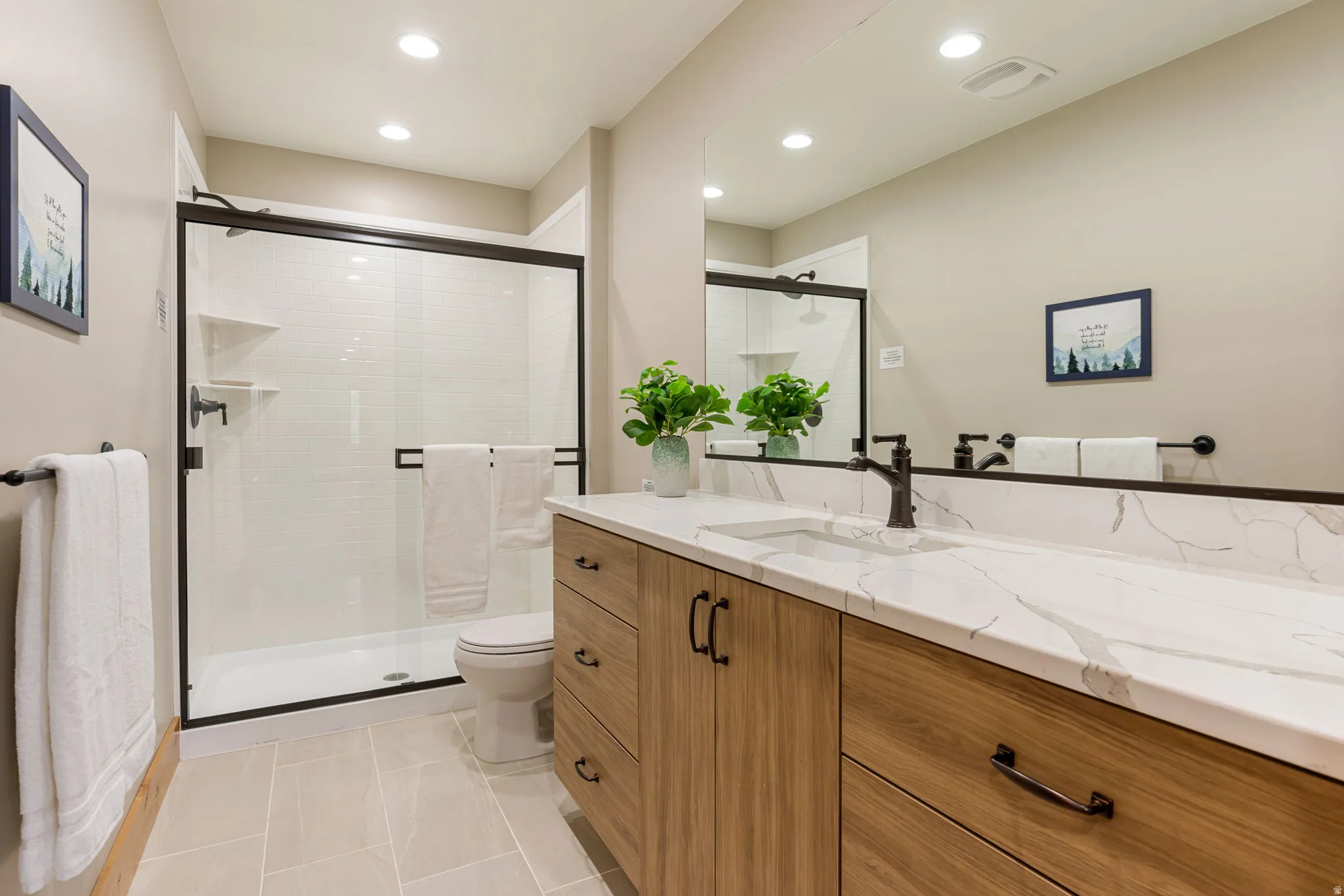 Spacious vanity with a white countertop featuring an integrated sink and black faucet
