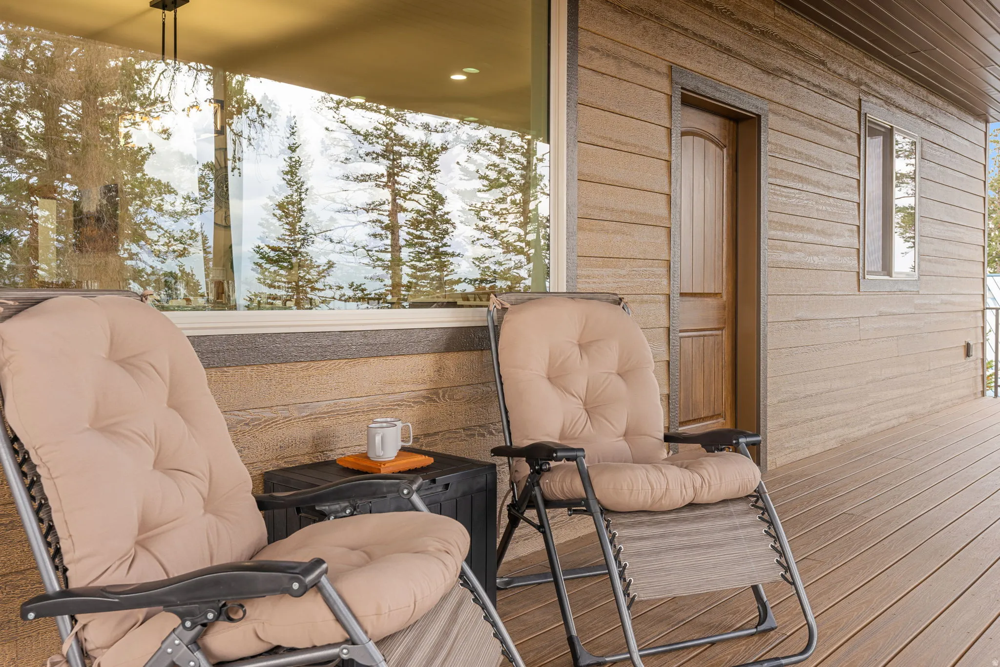 Expansive deck with wood-finish flooring, large windows, and a wood-panel exterior
