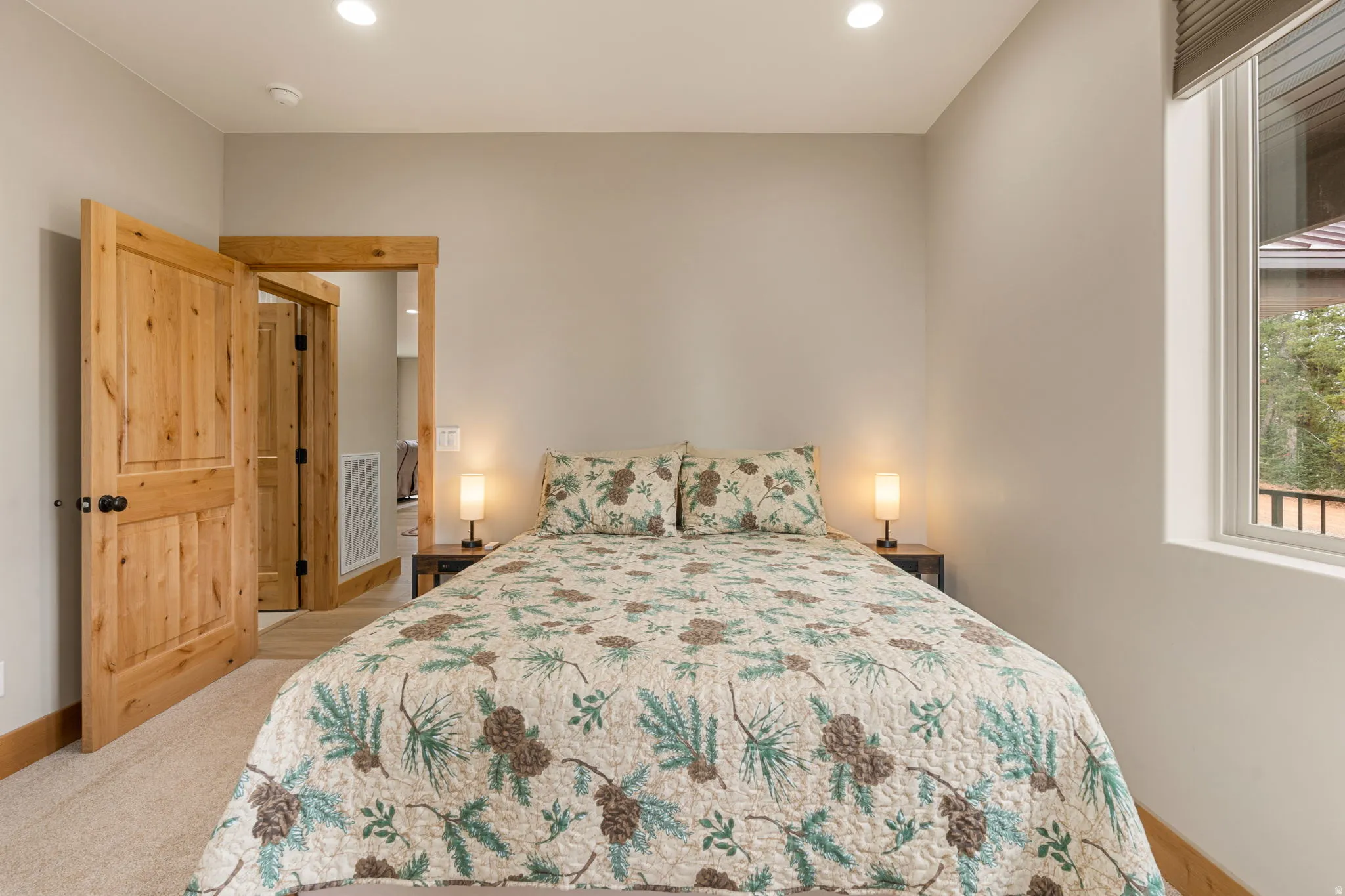Carpeted room with recessed lighting and natural wood doors