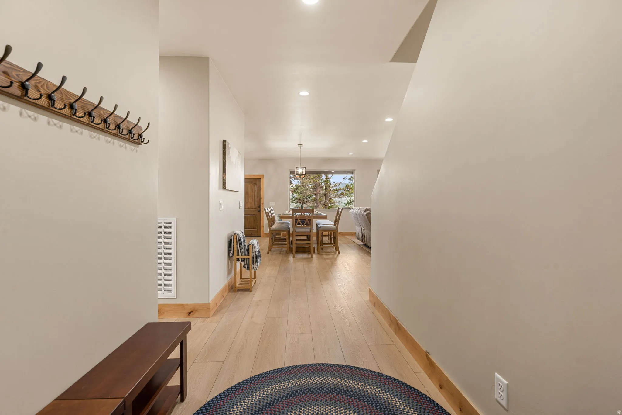 Recessed lighting illuminates the wood-finish flooring and solid wood trim
