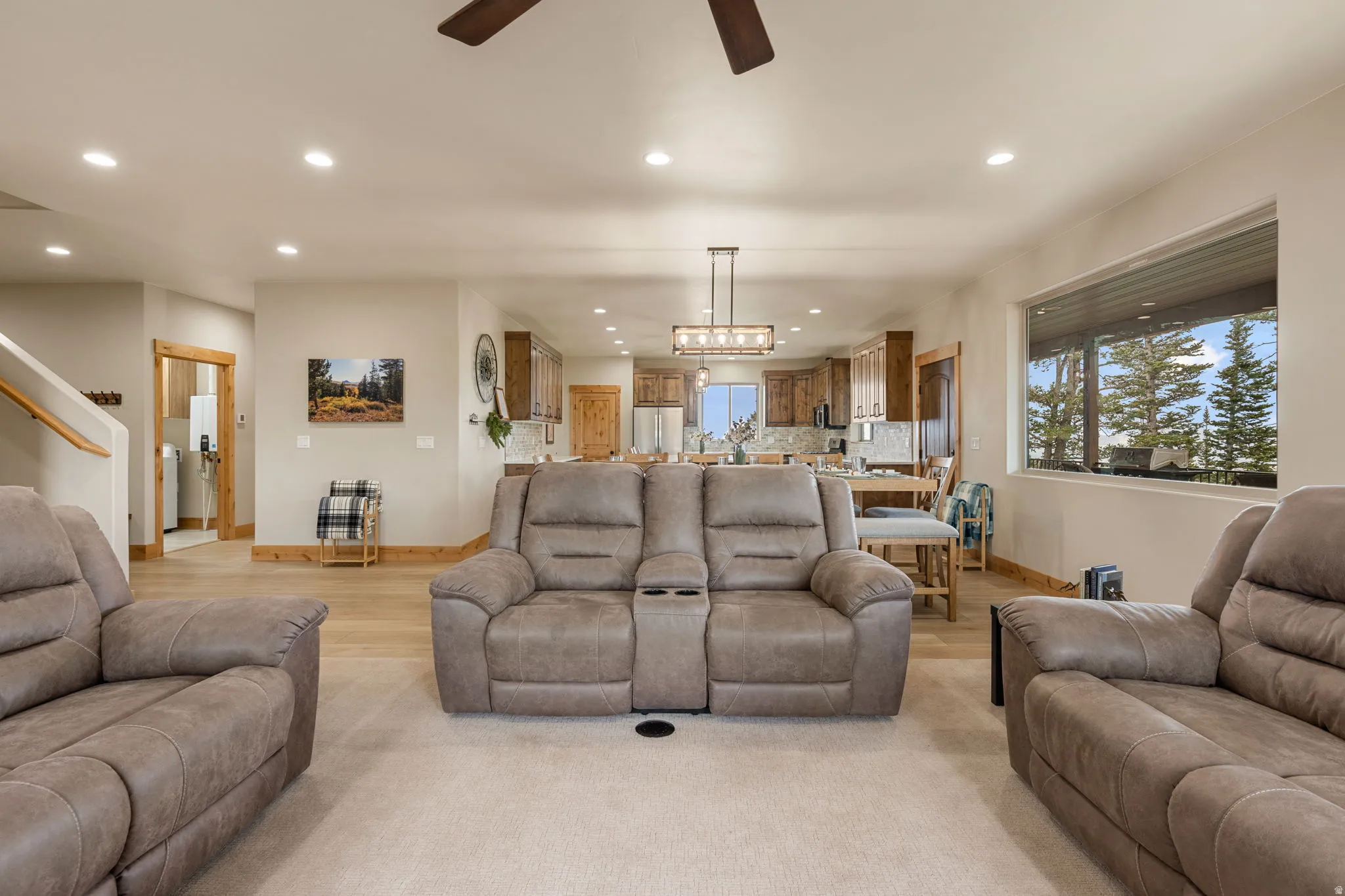 Open-concept living space with recessed lighting, wood-finish flooring, and a large picture window