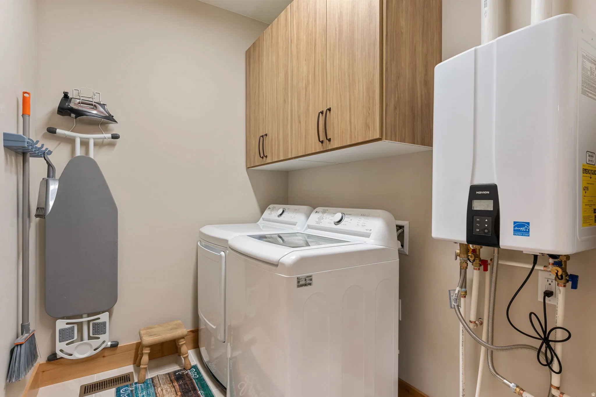 Laundry area featuring a top-load washing machine, front-load dryer, and wood-finish cabinetry