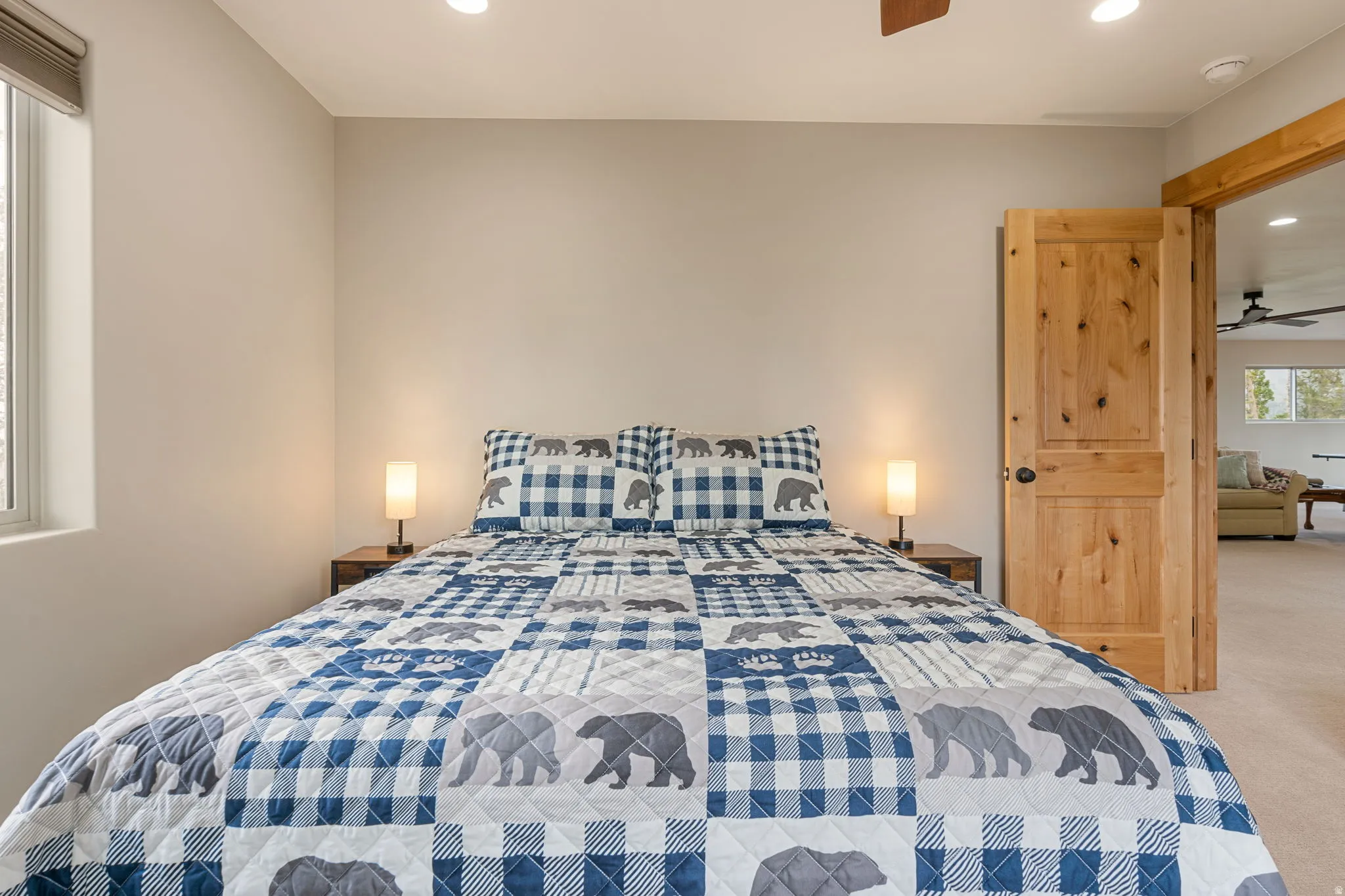 Recessed lighting, window with roller shade, wood-finish interior door, and ceiling fan