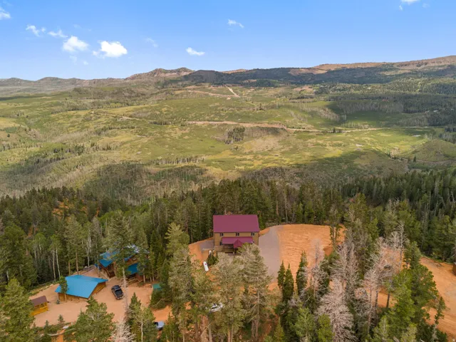 Expansive mountain landscape with a residence featuring a red roof