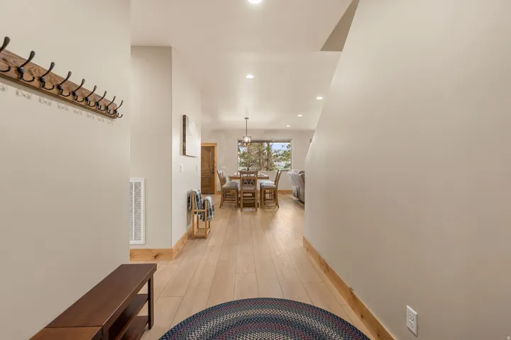 Recessed lighting illuminates the wood-finish flooring and solid wood trim