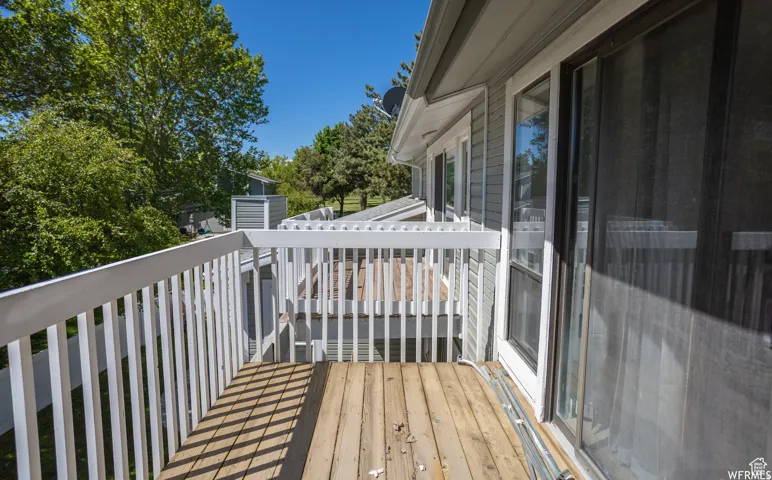 Wood-finish decking with white railing and sliding glass door
