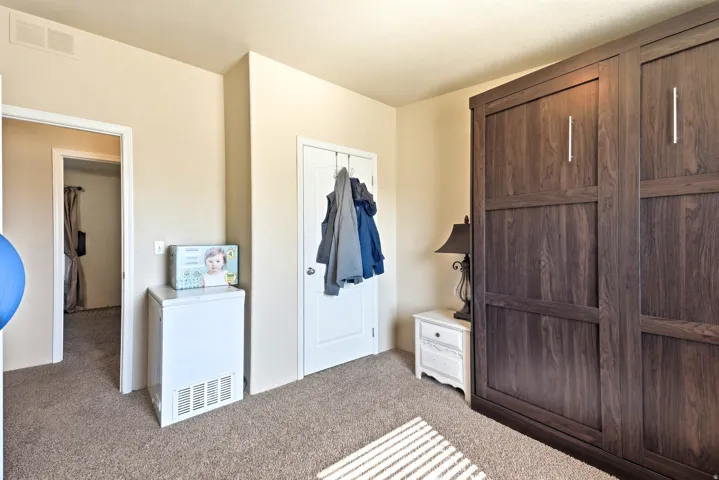 Plush carpeted flooring and pale neutral wall tones complement the dark wood-finish built-in cabinetry