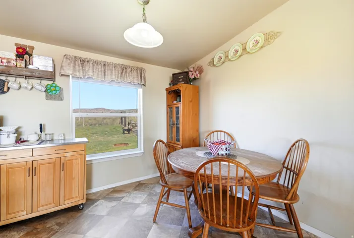 Laminate flooring, large window, pendant lighting, built-in cabinetry, neutral wall tones