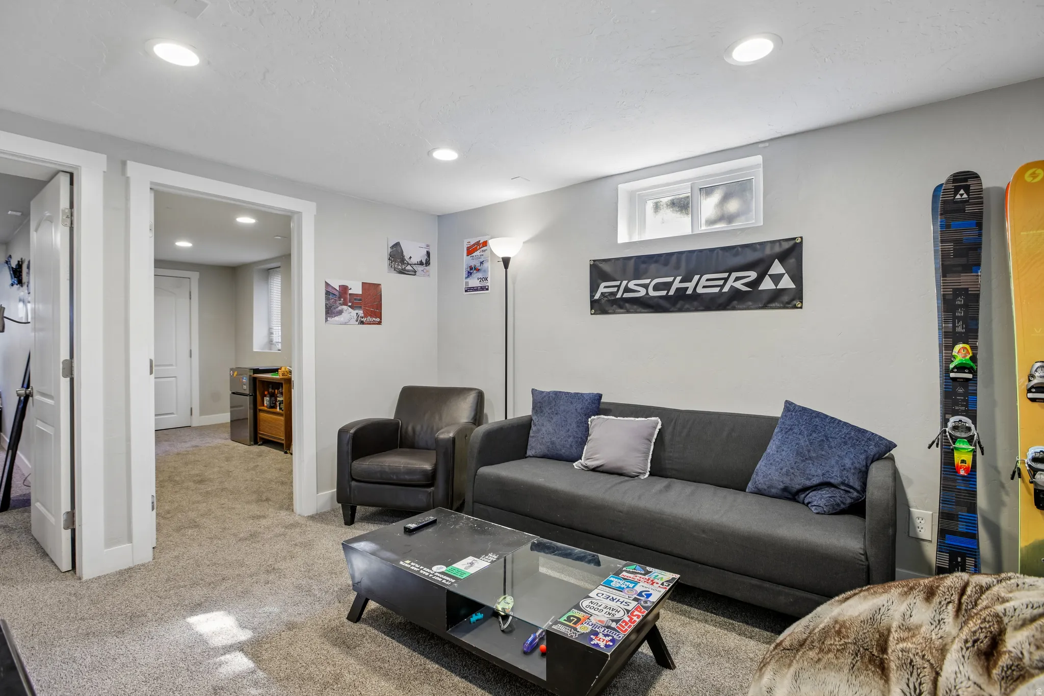 Recessed lighting illuminates a carpeted room featuring a transom window