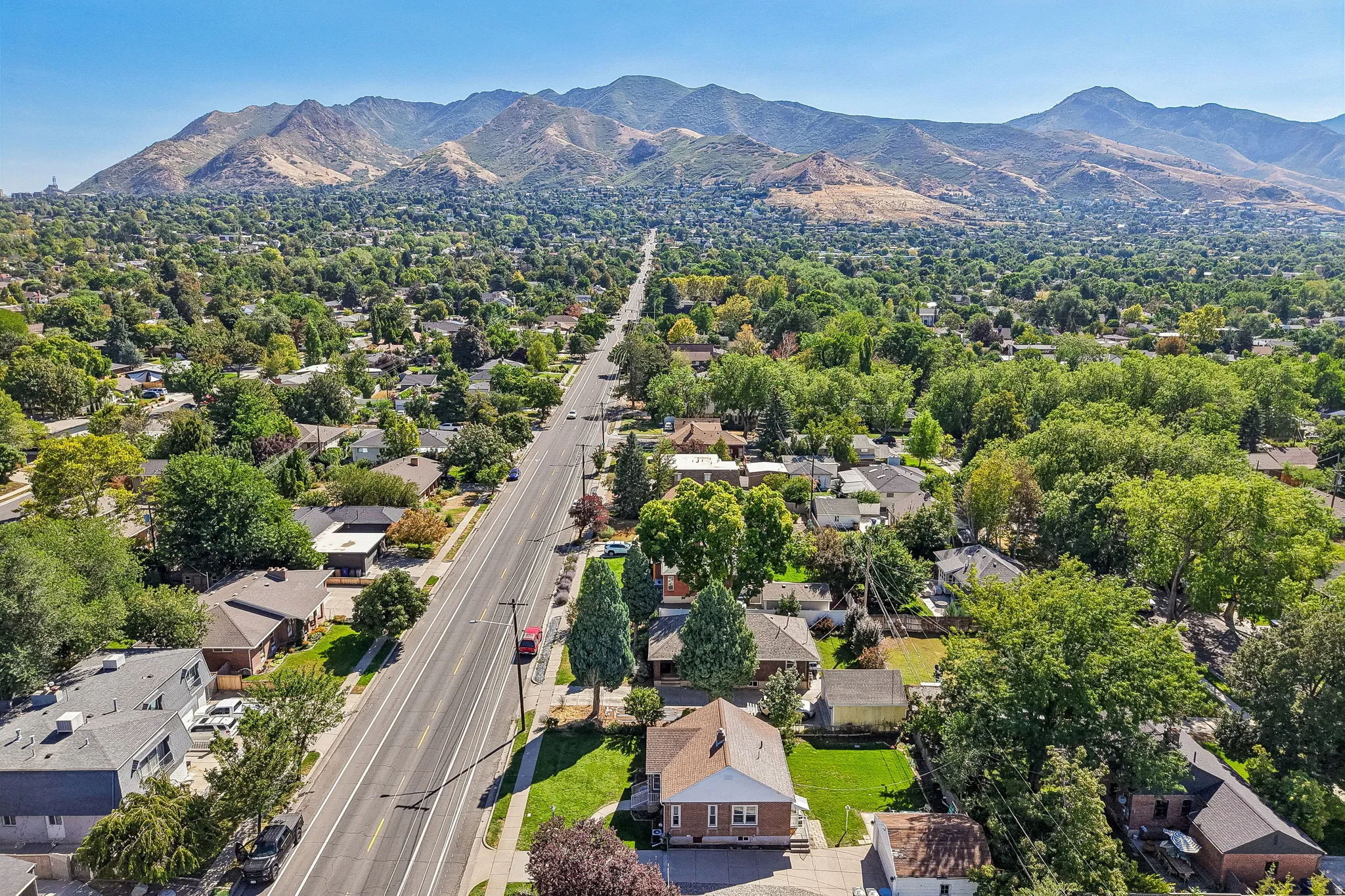 Neighborhood setting with established street, mature trees, and mountain backdrop