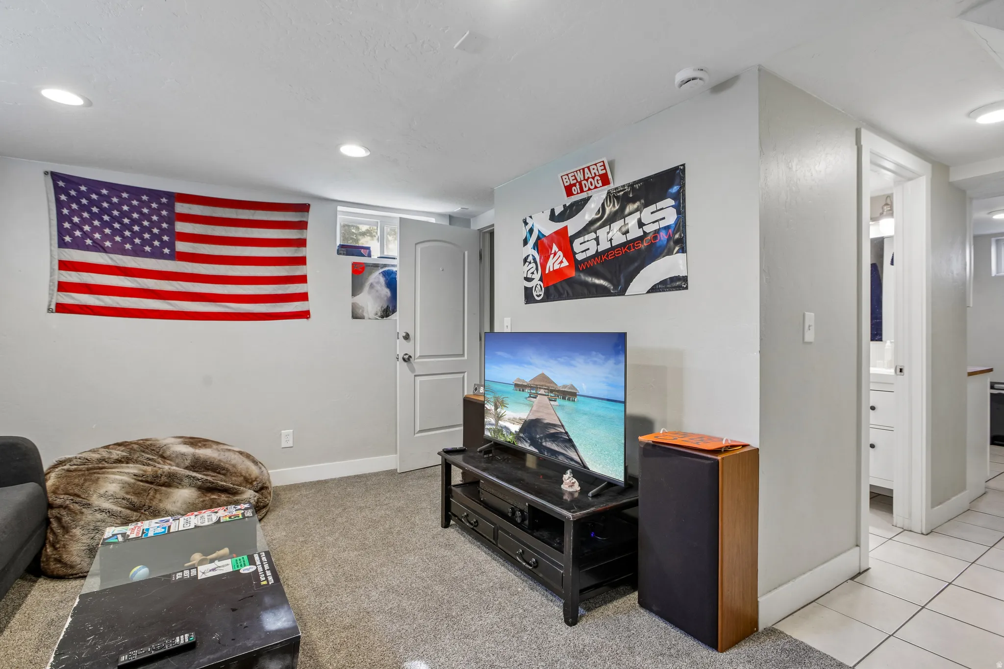 Recessed lighting, light gray wall paint, gray carpet flooring, white trim, and a white interior door