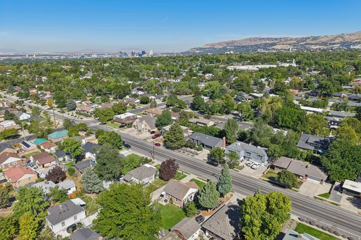 Residential neighborhood with mature trees, established properties, and distant city skyline