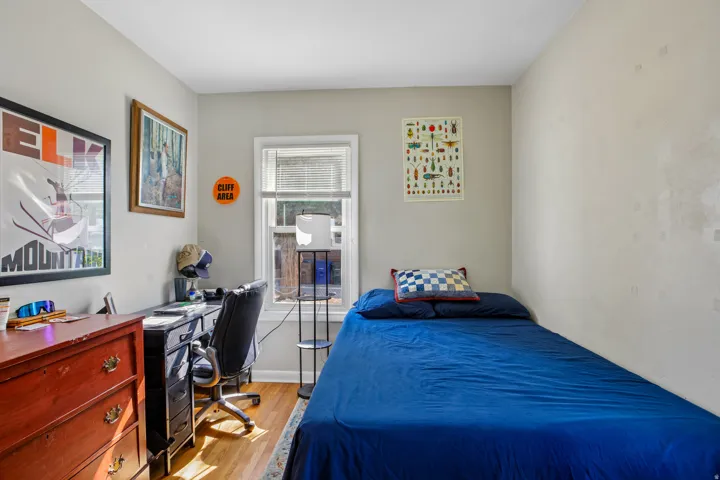 Hardwood flooring, painted walls, window with blinds, and ceiling