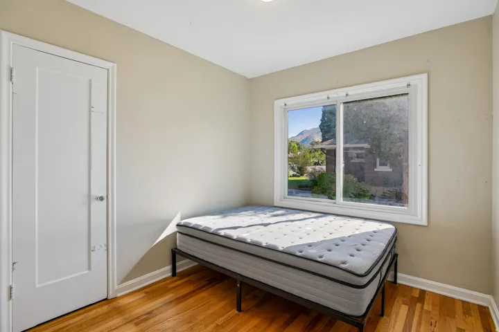 Hardwood flooring, white trim, recessed lighting, and a large window