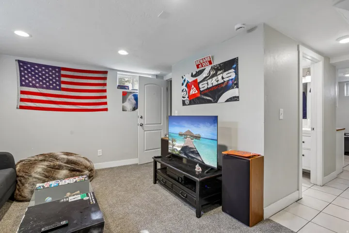 Recessed lighting, light gray wall paint, gray carpet flooring, white trim, and a white interior door