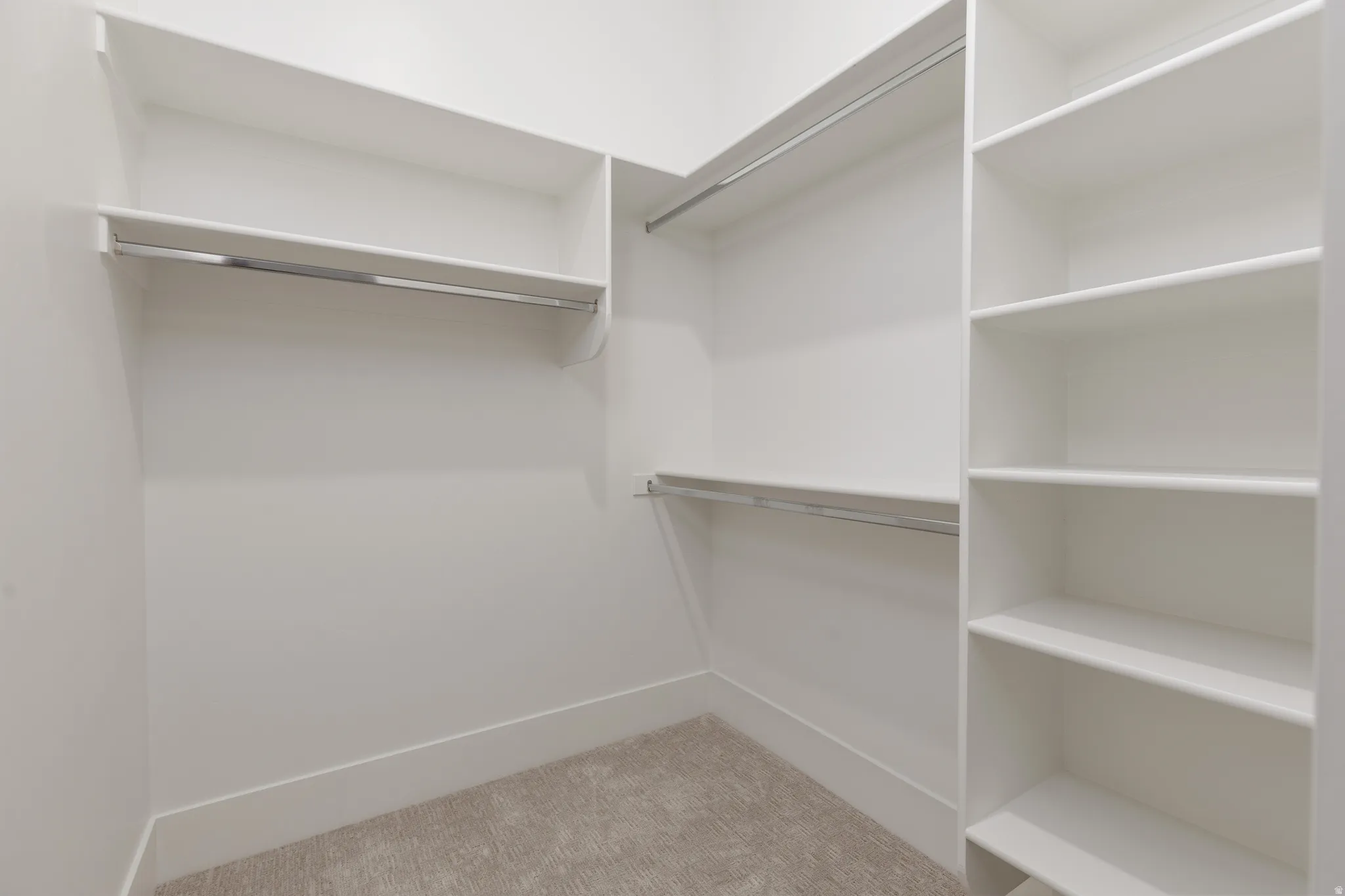 Built-in shelving, chrome hanging rods, and light-toned carpeting