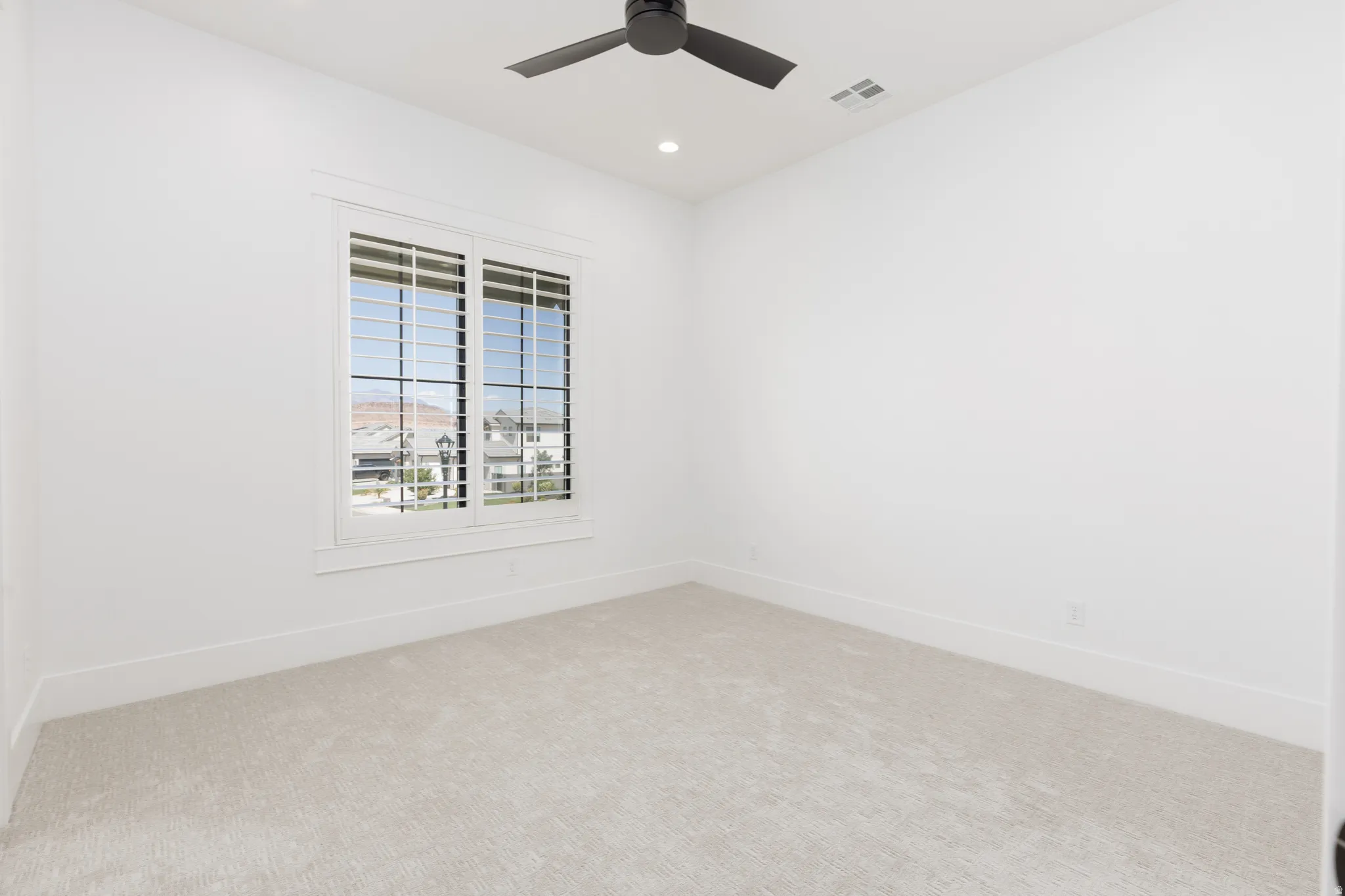 Recessed lighting, ceiling fan, white window shutters, light-colored carpeting, and white walls