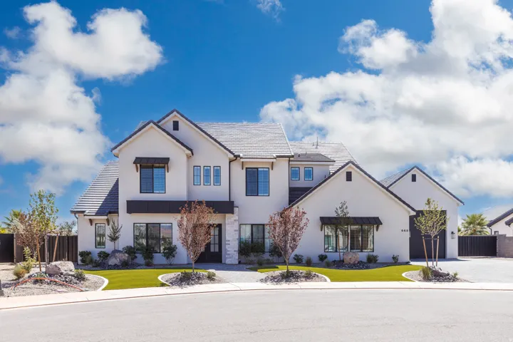 Modern stucco exterior with a gray tile roof, black-framed windows, and integrated garage