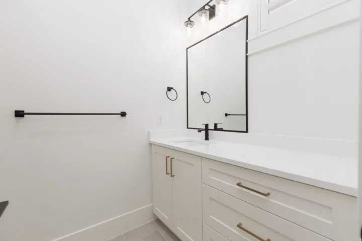 White shaker-style cabinetry with brass-finish hardware