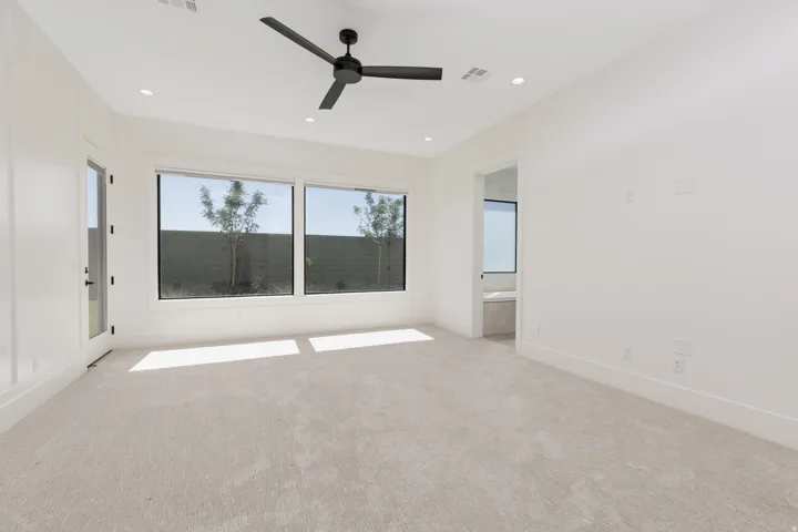 Light-toned carpet flooring, recessed ceiling lighting, and a modern ceiling fan