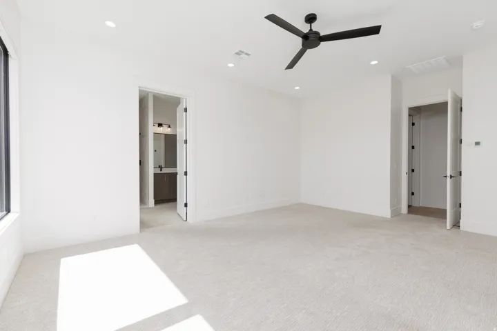 Plush carpeting, recessed lighting, expansive window, and a modern ceiling fan