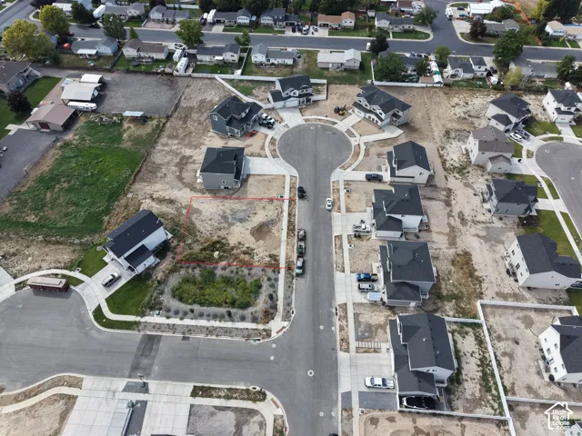 Cleared residential lot with established street infrastructure and surrounding homes