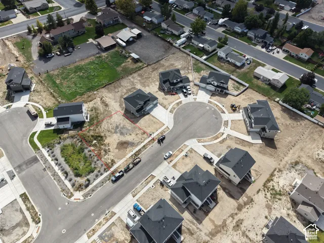 Aerial view of a residential development featuring newly constructed homes, paved streets, and cul-de-sacs