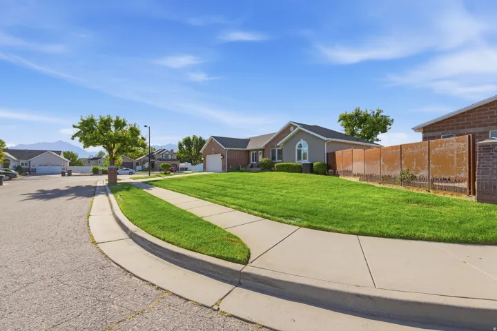 Front of home showing spacious side yard with fenced in courtyard.