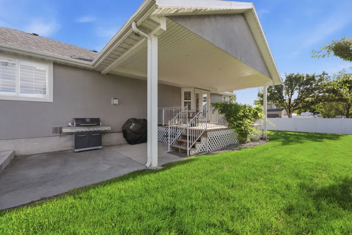 Expansive green lawn with a white privacy fence