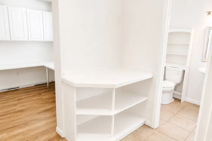 Built-in shelving unit with an integrated desktop and white cabinetry