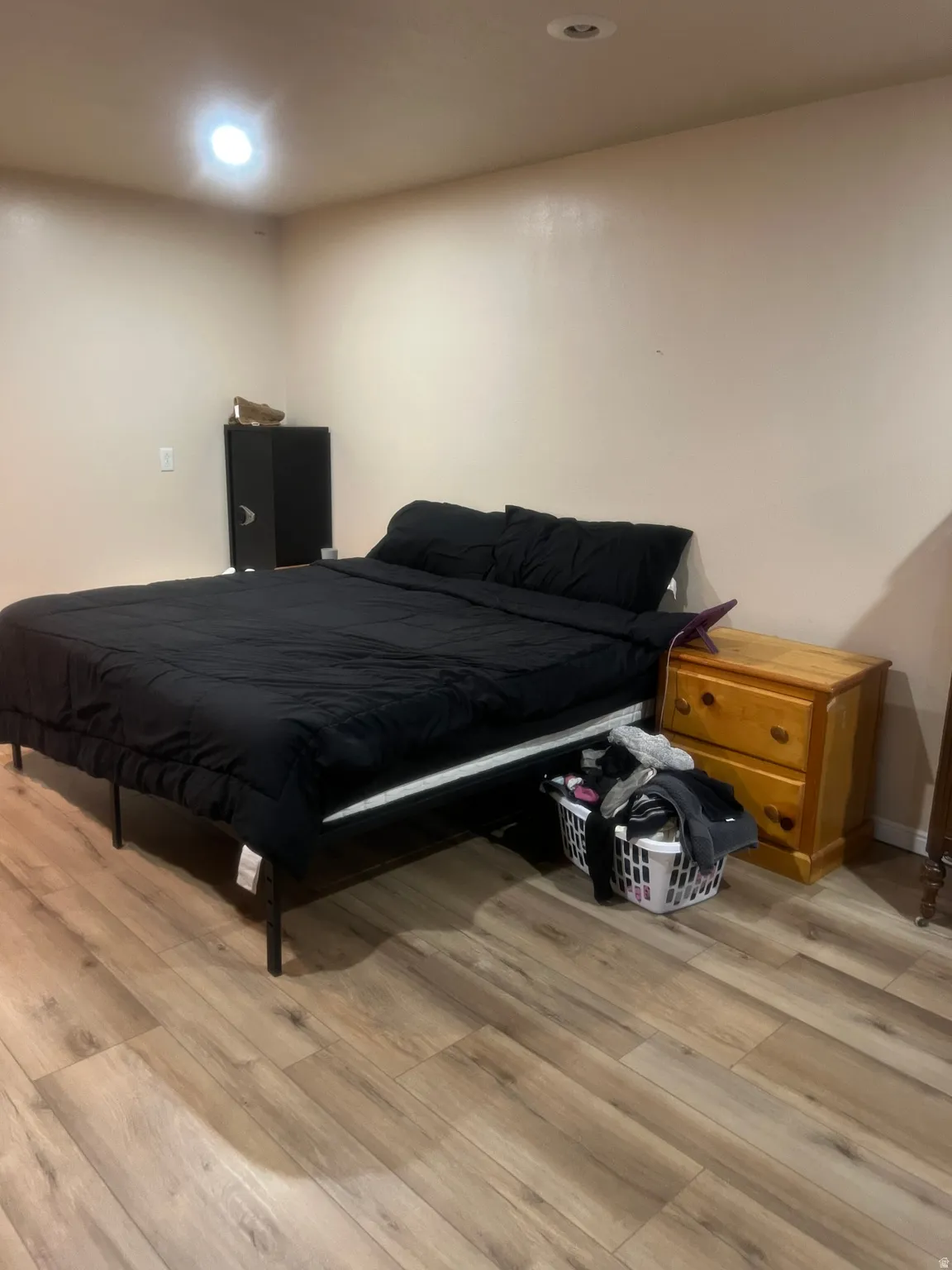 Neutral wall tones with recessed lighting and wood-finish flooring