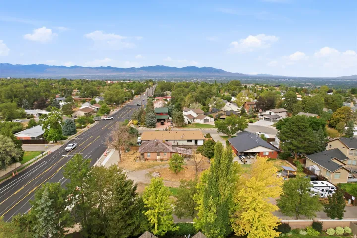 Residential neighborhood with mature trees, established infrastructure, and distant mountain scenery