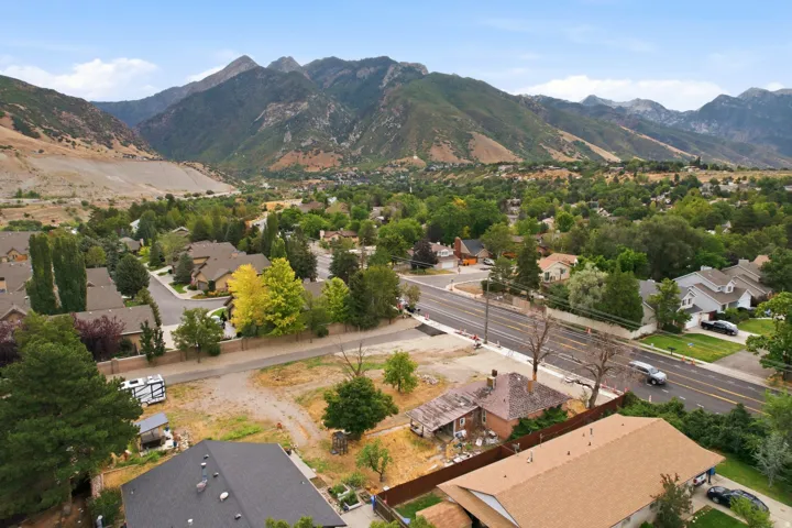 Expansive mountainous backdrop frames the surrounding residential area with mature trees and established homes